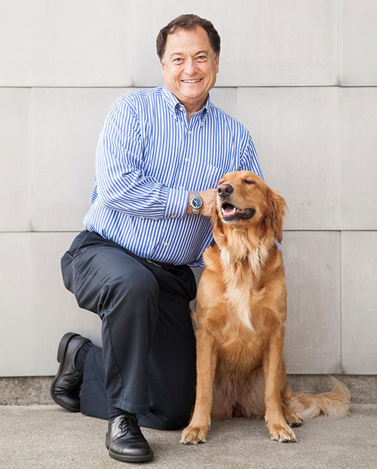 Dr. Kenneth Taylor, our experienced dentist, with one of our therapy Golden Retrivers